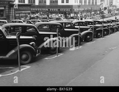 Vintage photo taken in 1938 of a row of cars parked diagonally in front of a series of parking meters in Omaha, Nebraska. Stock Photo