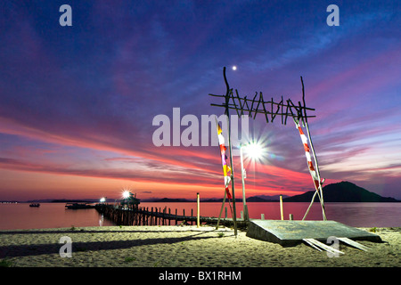 wooden pier on tropical Kanawa Island at dusk Stock Photo