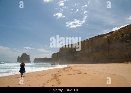 Woman walking along a sandy beach, Gibsons Steps, Port Campbell National Park, Great Ocean Road, Victoria, Australia Stock Photo