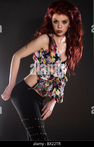 Fashion portrait of a young redhead female wearing a floral print shirt. Stock Photo