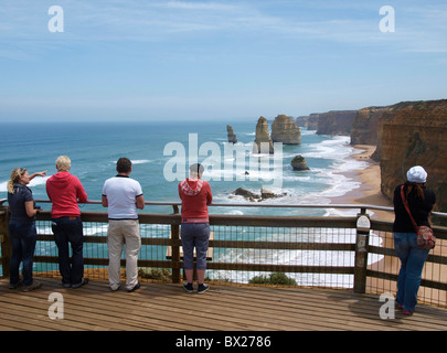 TOURISTS STAND AND ADMIRE TWELVE APOSTLES FROM VIEWING PLATFORM ON GREAT OCEAN ROAD, PORT CAMPBELL,  VICTORIA AUSTRALIA Stock Photo