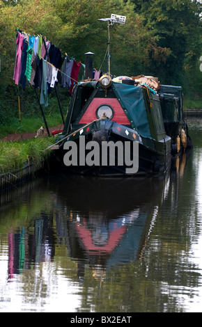 Canal Scene Liveaboard Barge moored alongside Towpath with colourful laundry hung out on temporary clothes line Stock Photo