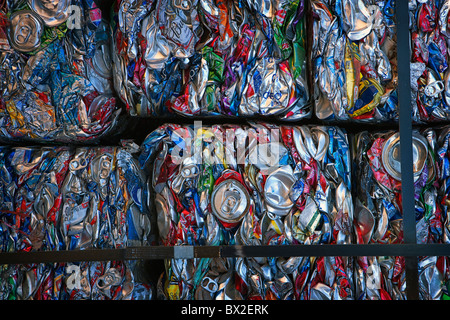 Crushed aluminum cans are cubed, baled, and stacked high ready for recycling. Stock Photo