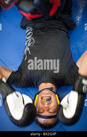 Caucasian boxer grimacing on mat Stock Photo
