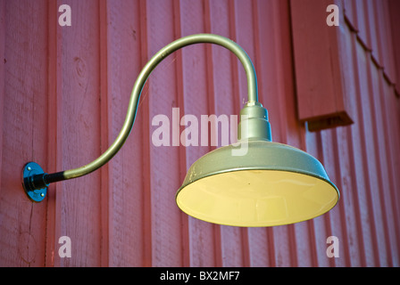 old outdoor light on wooden wall of barn painted in red color Stock Photo