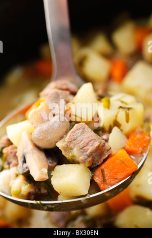 Hearty beef and potatoes stew with vegetables served with ladle Stock Photo