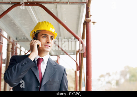 architect talking on mobile phone in construction site Stock Photo