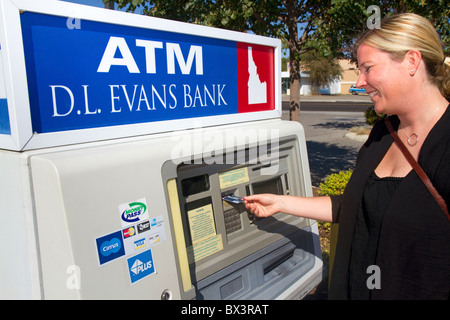 Woman making a cash withdrawal from and ATM in Boise, Idaho, USA. MR Stock Photo