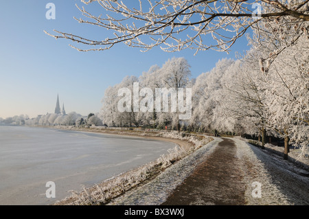 Lichfield cathedral of St Saint Chad with frozen Stowe Pool in winter sunshine CATHEDRAL STOWE POOL FROZEN ICE LICHFIELD WINTER Stock Photo