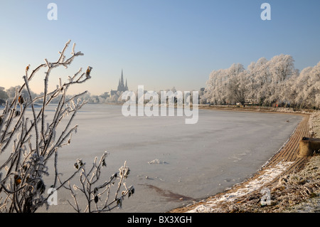 Lichfield cathedral of St Saint Chad with frozen Stowe Pool in winter sunshine Stock Photo