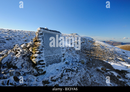 Snow and ice crusted Gough Memorial at the summit of Striding Edge on Helvellyn in the English Lake District Stock Photo