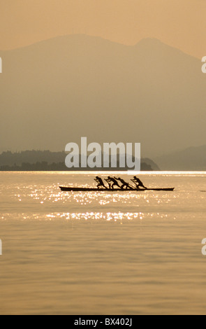 Four men rowing in the Venetian style known as 'Voga alla Veneta', on Lake Garda, Italy Stock Photo