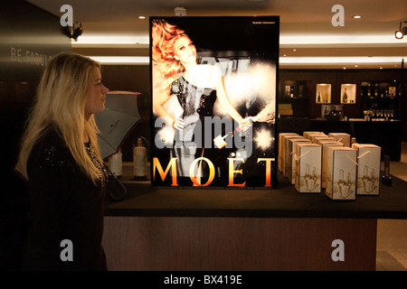 Blonde girl looking at the Moet and Chandon Champagne display, The Moet and Chandon House, Avenue de Champagne, Epernay, France Stock Photo