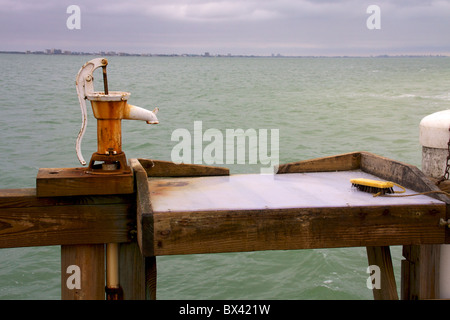 Fish cleaning station on pier with water pump Stock Photo