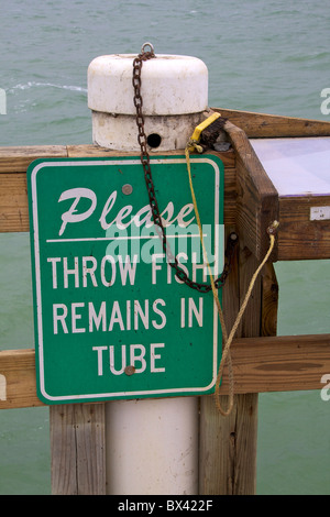 Sign on fishing pier about fish remains Stock Photo