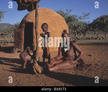 Himba-Ovahimba trunk tribe woman hut children Kraal Kral Kaokoveld Namibia Africa Stock Photo