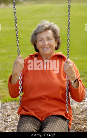 Elderly woman on children playground Stock Photo