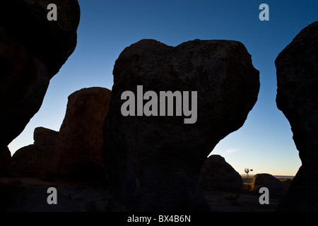 Old farm windmill amidst the silhouetted rock formations at the City of Rocks State Park in New Mexico, USA. Stock Photo