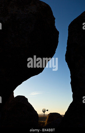 Old farm windmill amidst the silhouetted rock formations at the City of Rocks State Park in New Mexico, USA. Stock Photo