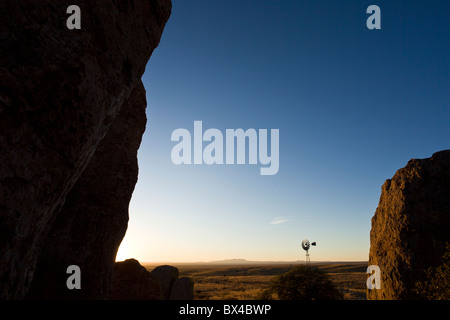 Old farm windmill amidst the silhouetted rock formations at the City of Rocks State Park in New Mexico, USA. Stock Photo