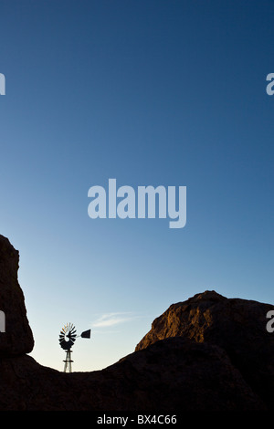 Old farm windmill amidst the silhouetted rock formations at the City of Rocks State Park in New Mexico, USA. Stock Photo