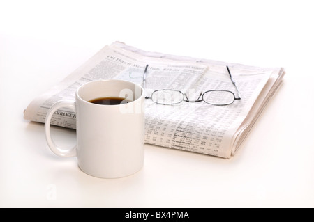 Business newspapers, cup of coffee and glasses isolated on a white background -Focus is on the cup- Stock Photo