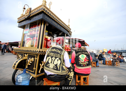 ISTANBUL, TURKEY. Street food vendors in colourful waistcoats by a pickle stall on the Golden Horn waterfront in Eminonu. 2010. Stock Photo