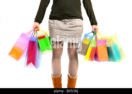 Young woman carrying gift boxes, cardboard boxes, of different sizes and colors, in different shopping bags. Stock Photo
