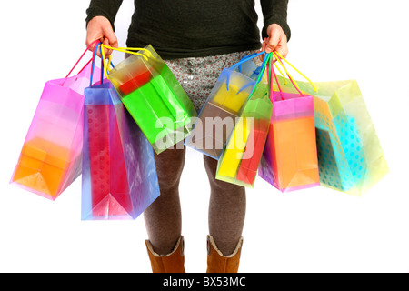 Young woman carrying gift boxes, cardboard boxes, of different sizes and colors, in different shopping bags. Stock Photo