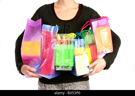 Young woman carrying gift boxes, cardboard boxes, of different sizes and colors, in different shopping bags. Stock Photo