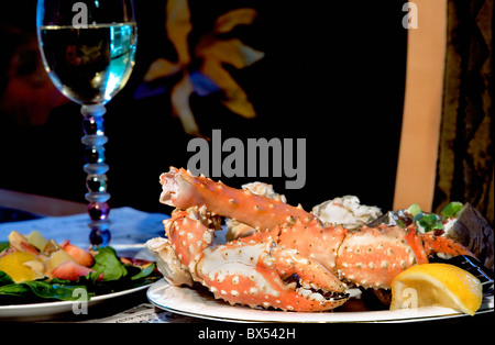 Delicious Alaskan King Crab dinner with a strawberry/spinach salad and a baked potato Stock Photo