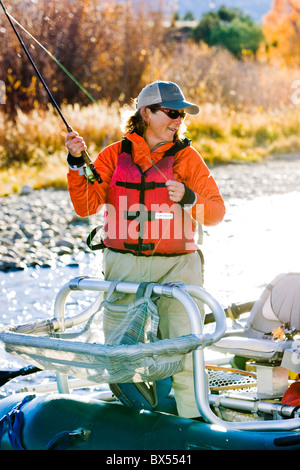 Woman fly fishing from a boat on the Arkansas River, near Salida, Colorado, USA Stock Photo