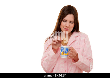 woman dunking a biscuit in a mug of tea Stock Photo
