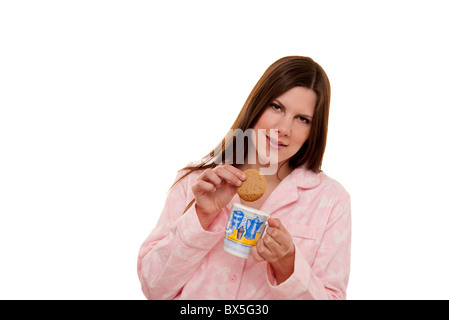 woman dunking a biscuit in a mug of tea Stock Photo
