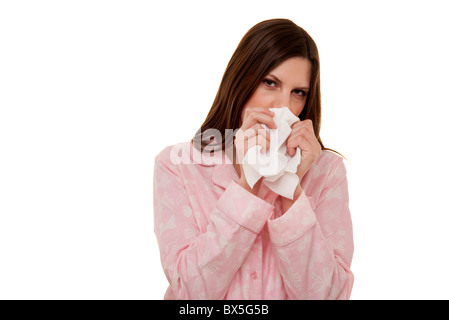 woman blowing her nose wearing pyjamas Stock Photo