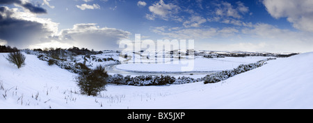 Panoramic view of snow-covered landscape beneath winter sky looking towards meandering River Aln, Lesbury, Northumberland, UK Stock Photo