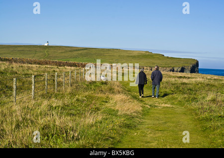 dh  BIRSAY ORKNEY Two walkers on footpath with dog Brough of Birsay north coastal path Stock Photo