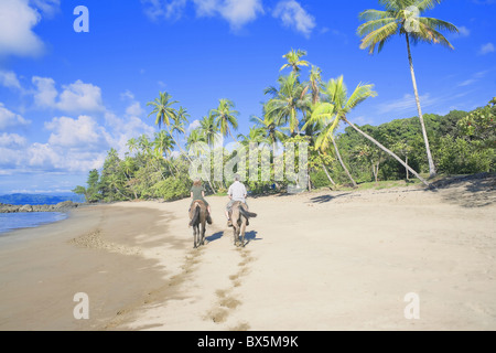 Horseback riding on tropical beach, Baia Drake, Osa Peninsula, Costa Rica, Central America Stock Photo