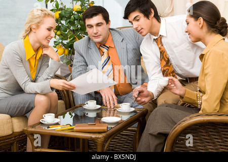 Portrait of successful people communicating in office around table and having tea Stock Photo