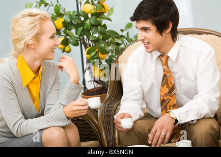 Portrait of smart colleagues having conversation in office during coffee break Stock Photo