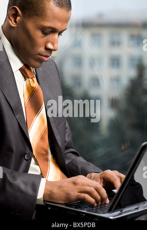 Photo of handsome employee working in office with laptop in front Stock Photo