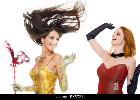 Photo of joyful actresses in fashionable dresses laughing over white background Stock Photo