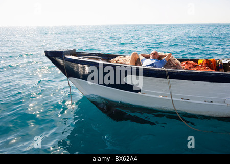 Fisherman asleep on nets Stock Photo