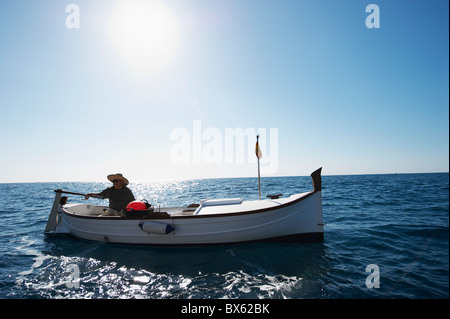 The active man is fishing on sea from the rocky coast. Fisherman check  pushing bait on the fishing line, prepare rod and than throw lure into  peaceful Stock Photo - Alamy