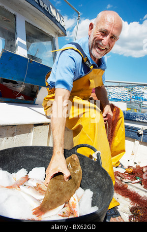 Fisherman holding fish Stock Photo