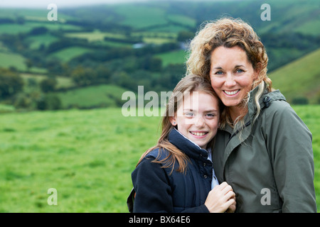 Mother and daughter hugging in field Stock Photo