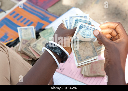 A woman counts Liberian dollars in Kakata, Liberia, West Africa. Stock Photo