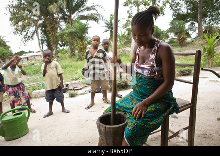 A young woman grinds cassava flour in Kakata, Liberia, West Africa. Stock Photo