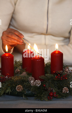Woman lighting advent candles, Saint Nicolas de Veroce, Haute Savoie, France, Europe Stock Photo