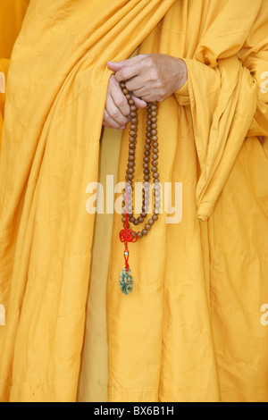 Buddhist monk holding prayer beads, Thiais, Val de Marne, France, Europe Stock Photo